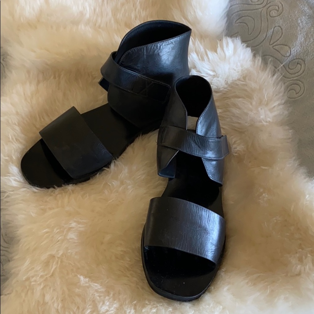 Flat black leather sandals with velcro strap.